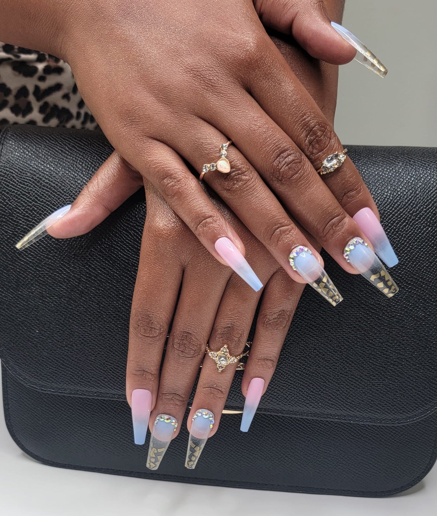 Model Wearing Casket Ready Beauty's Coffin-shaped long-length glossy baby pink, baby blue and clear nails with accent gold accent tips and rhinestones.
