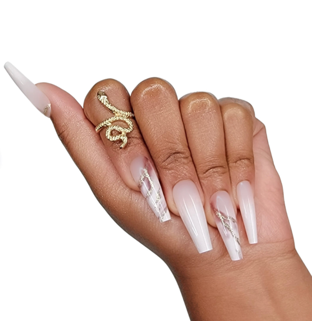 Model Wearing Casket Ready Beauty's Coffin-shaped long-length glossy marbled pinkish beige, cream, white, and burgundy nails decorated with gold glitter.